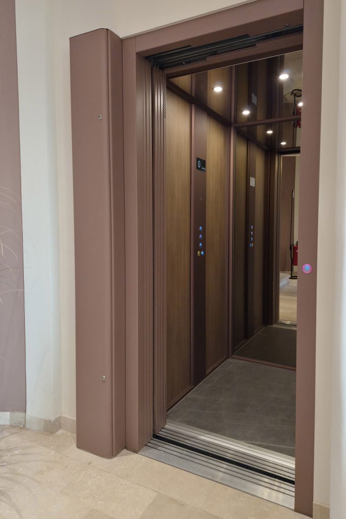 Un home lift Eltec Lift HLB elettrico, installato in una villa del 1700 restaurata e trasformata in struttura ricettiva, integrato nell’atrio tramite struttura AU. Finiture armonizzate con le pareti, design discreto e tecnologia elettrica garantiscono comfort, eleganza e rispetto del contesto storico, trasformando l’impianto in elemento architettonico di valore. Dettaglio dell'impianto in apertura porta.