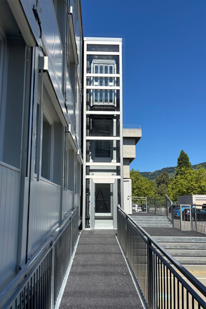 Home lift Eltec Lift HLB elettrico con struttura TA, vetro fumé e porte a soffietto inox in cabina; soluzione su misura che unisce accessibilità, comfort e design integrato.